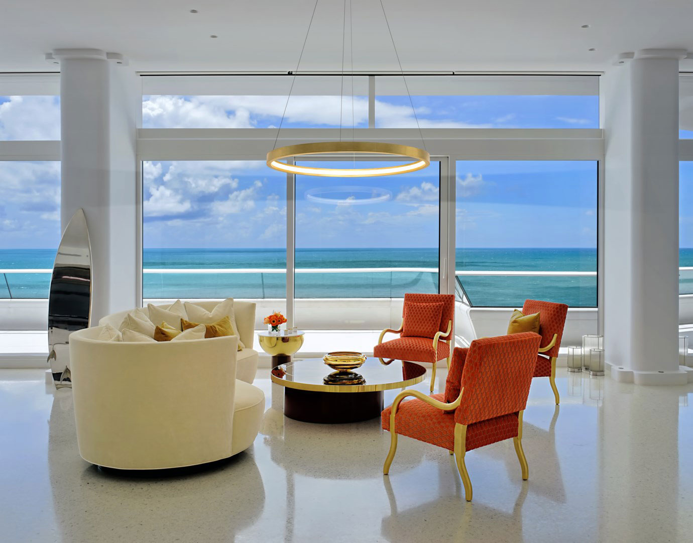 Modern ocean view living room with gold ring chandelier